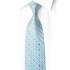 Ice-blue silk necktie tied beneath white collar, with diagonal bands, blue mosaic pattern and sparkling rhinestones
