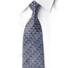 Navy blue rhinestone silk necktie knotted on white dress shirt collar showing seigaiha scallop wave pattern with crystal silver sparkle rhinestone embellishments