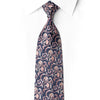 San-Dee men's 100% silk necktie in midnight navy with all-over baroque floral scroll jacquard in rose gold and blush tones, with hand-applied crystal rhinestone accents tracing the vine pattern – front knotted view on white dress shirt