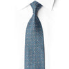 Full-length blue silk necktie with repeating silver geometric floral pattern and scattered crystals