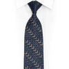 San-Dee men's 100% silk necktie in navy blue with all-over chevron zigzag jacquard weave and hand-applied multi-colour crystal rhinestones in gold, white, and red forming geometric step patterns – front knotted view on white dress shirt